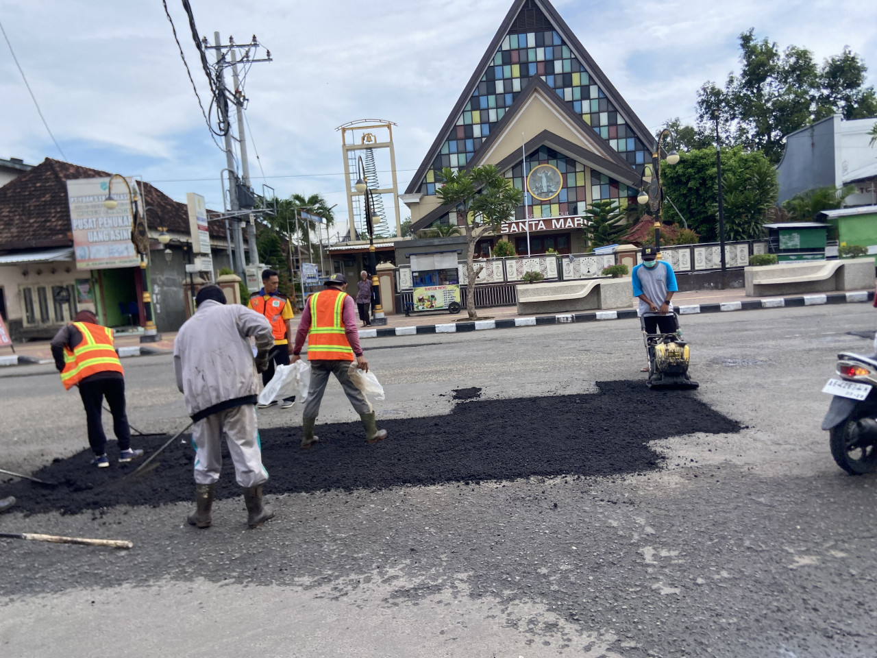 Pekerja melakukan perbaikan jalan di Ponorogo. (Foto: Ahmad fauzani/jatimnow.com)