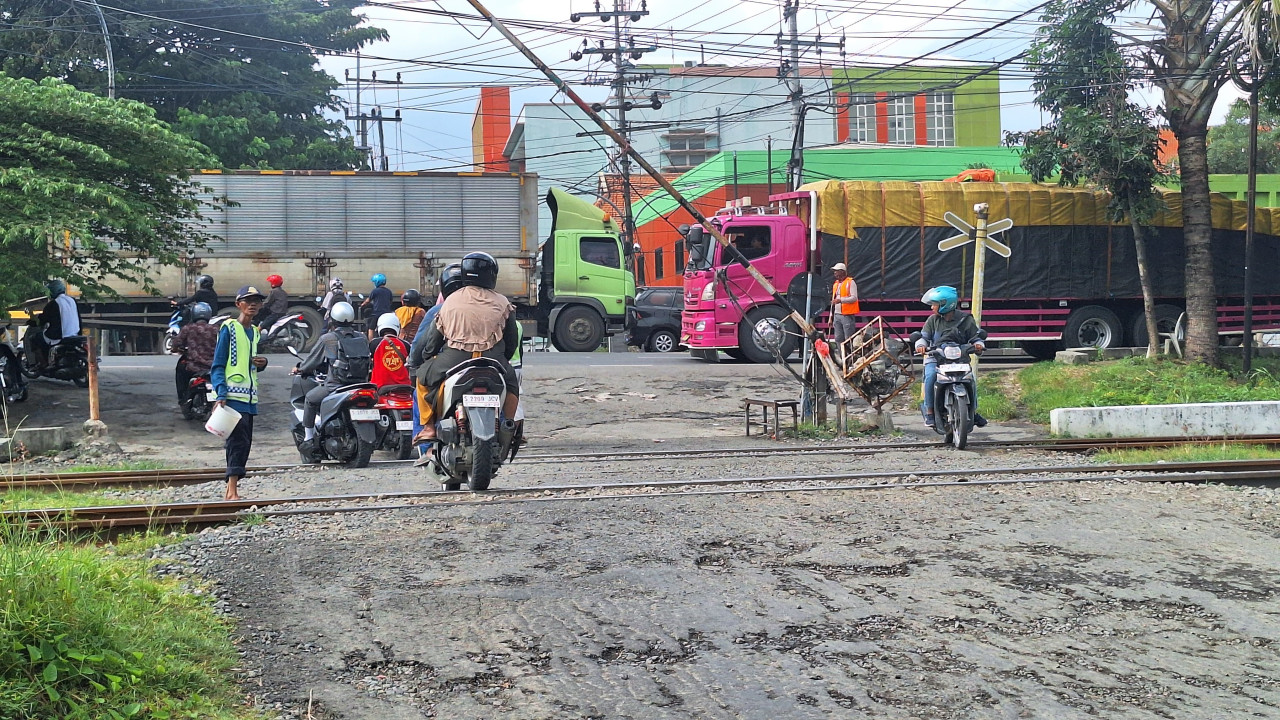 Potret penjagaan perlintasan sebidang di Jalan Veteran Lamongan. (Foto : Adyad Ammy Iffansah/jatimnow.com)