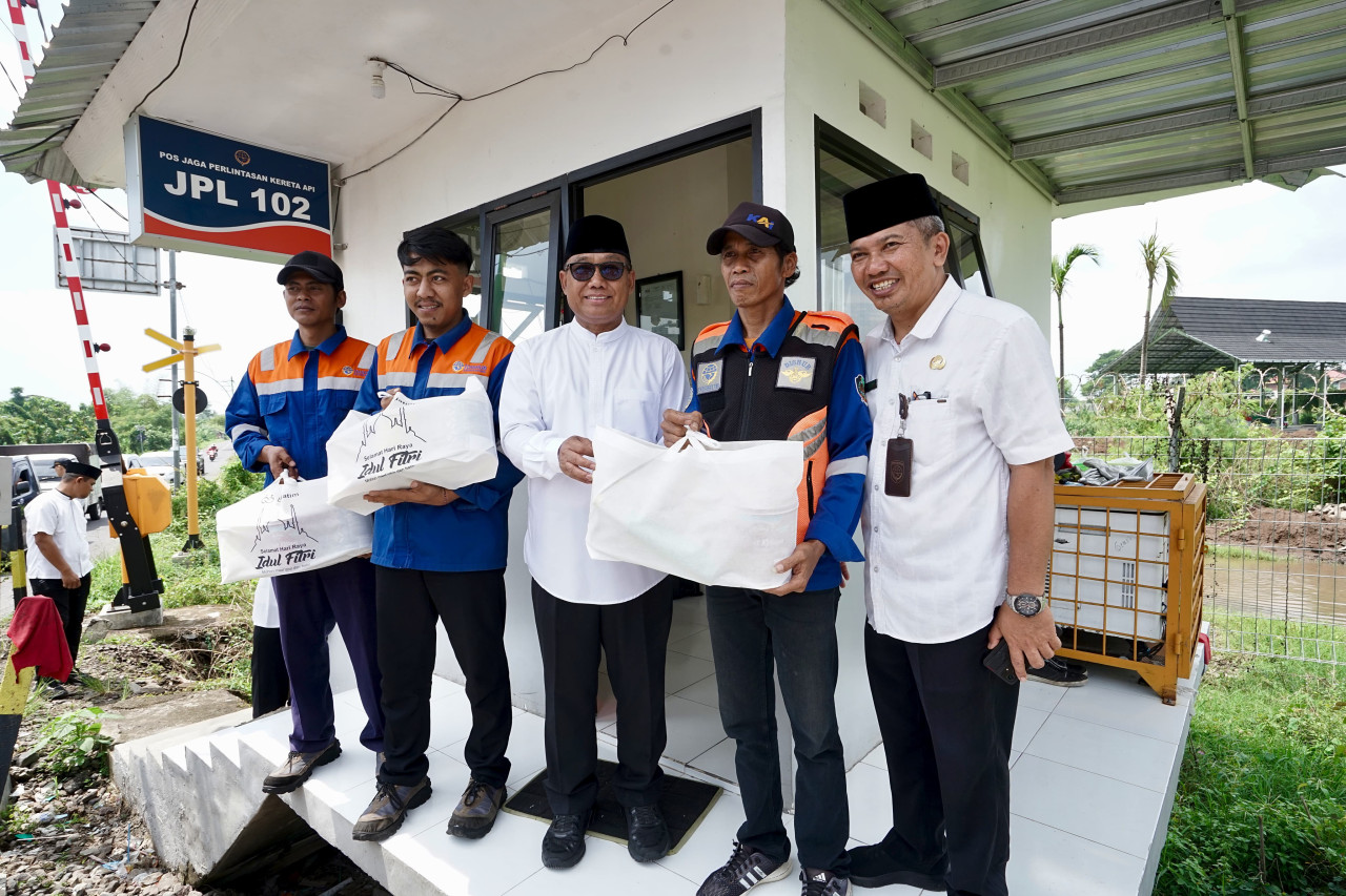 Wakil Bupati Mujiono menyerahkan paket sembako pada penjaga perlintasan kereta api. (Foto: Kominfo Pemkab Banyuwangi for jatimnow.com)