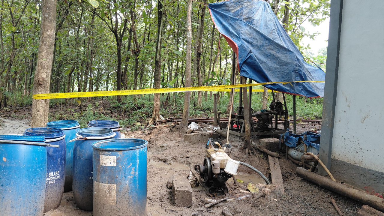 Lokasi pengeboran sumur yang mengeluarkan bau solar di Lamongan dipasang garis Polisi. (Foto : Adyad Ammy Iffansah/jatimnow.com)