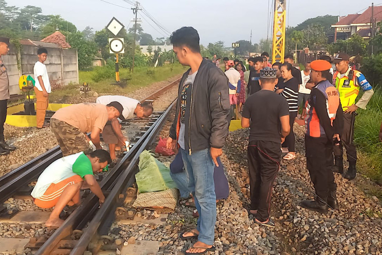 Polisi bersama warga evakuasi balita tertabrak kereta api. (Foto: Bramanta Pamungkas/jatimnow.com)