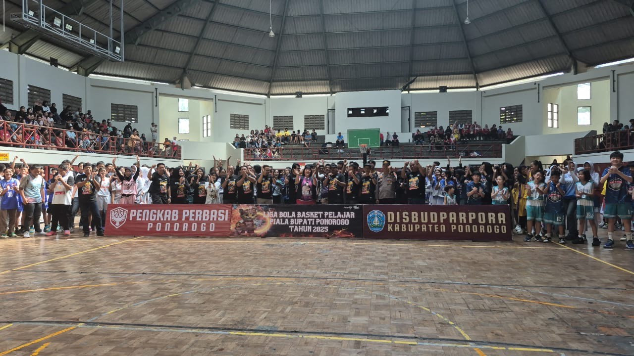 Kepala Disbudparpora Ponorogo, Judha Slamet Sarwo Edi (tengah, bertopi), bersama panitia dan para atlet saat pembukaan Liga Bola Basket Pelajar Piala Bupati Ponorogo 2025 di GOR Singodimedjo. (Foto: Ahmaad Fauzani/jatimnow.com)