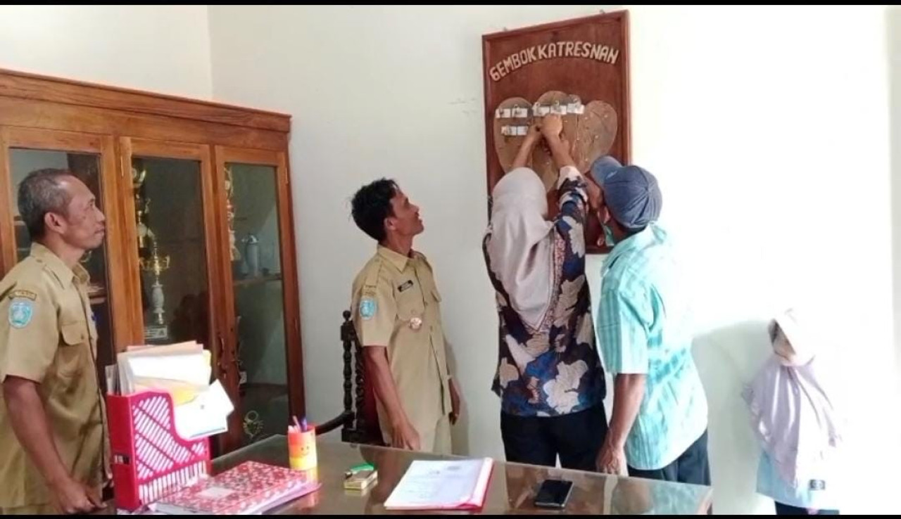 Siti Aminah dan Toni, pasutri asal Desa Bringinan, saat mengikuti prosesi pemasangan Gembok Katresnan disaksikan Kepala Desa Barno Ponorogo. (Foto: Pemdes Bringinan/jatimnow.com)