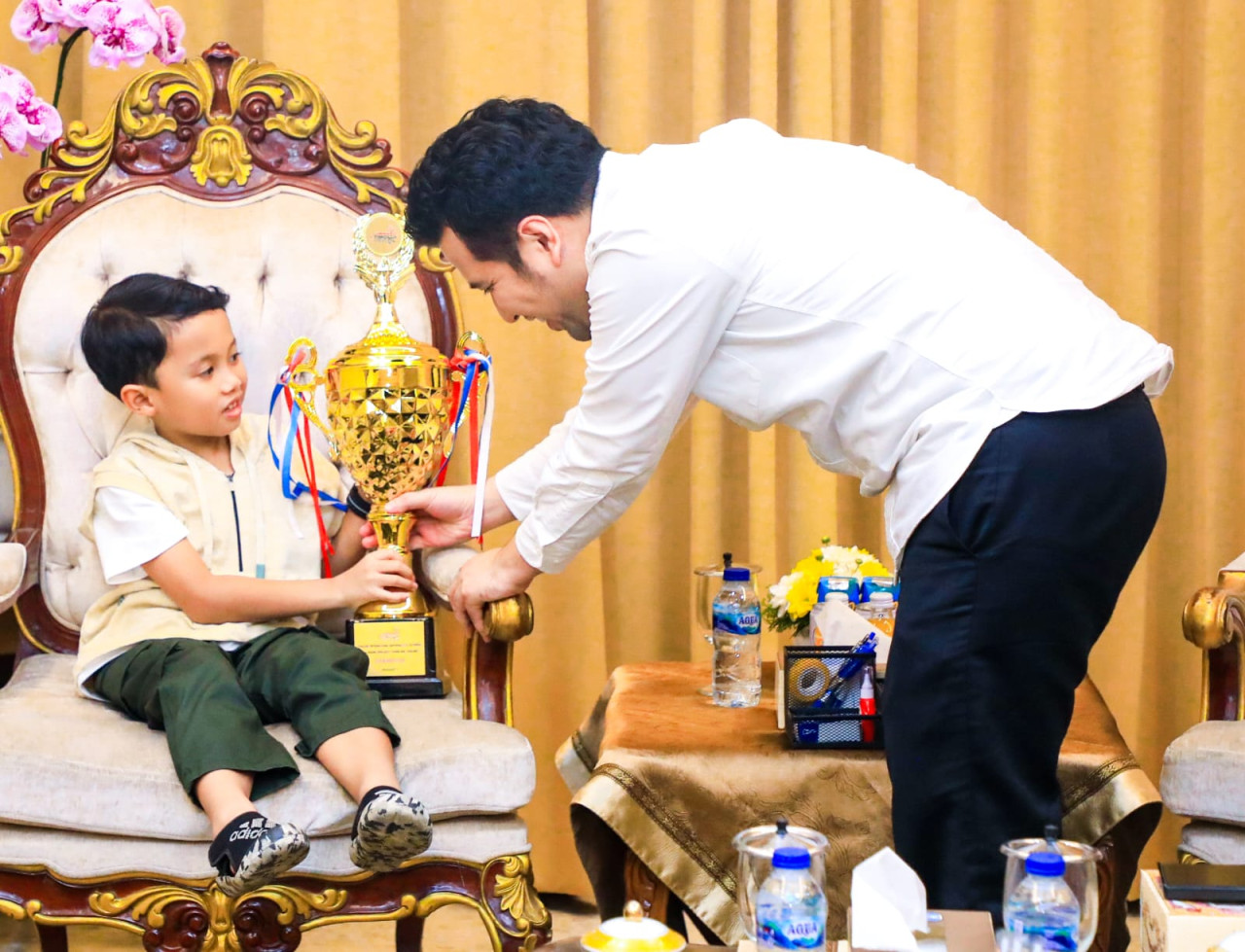 Rama menunjukkan piala juaranya