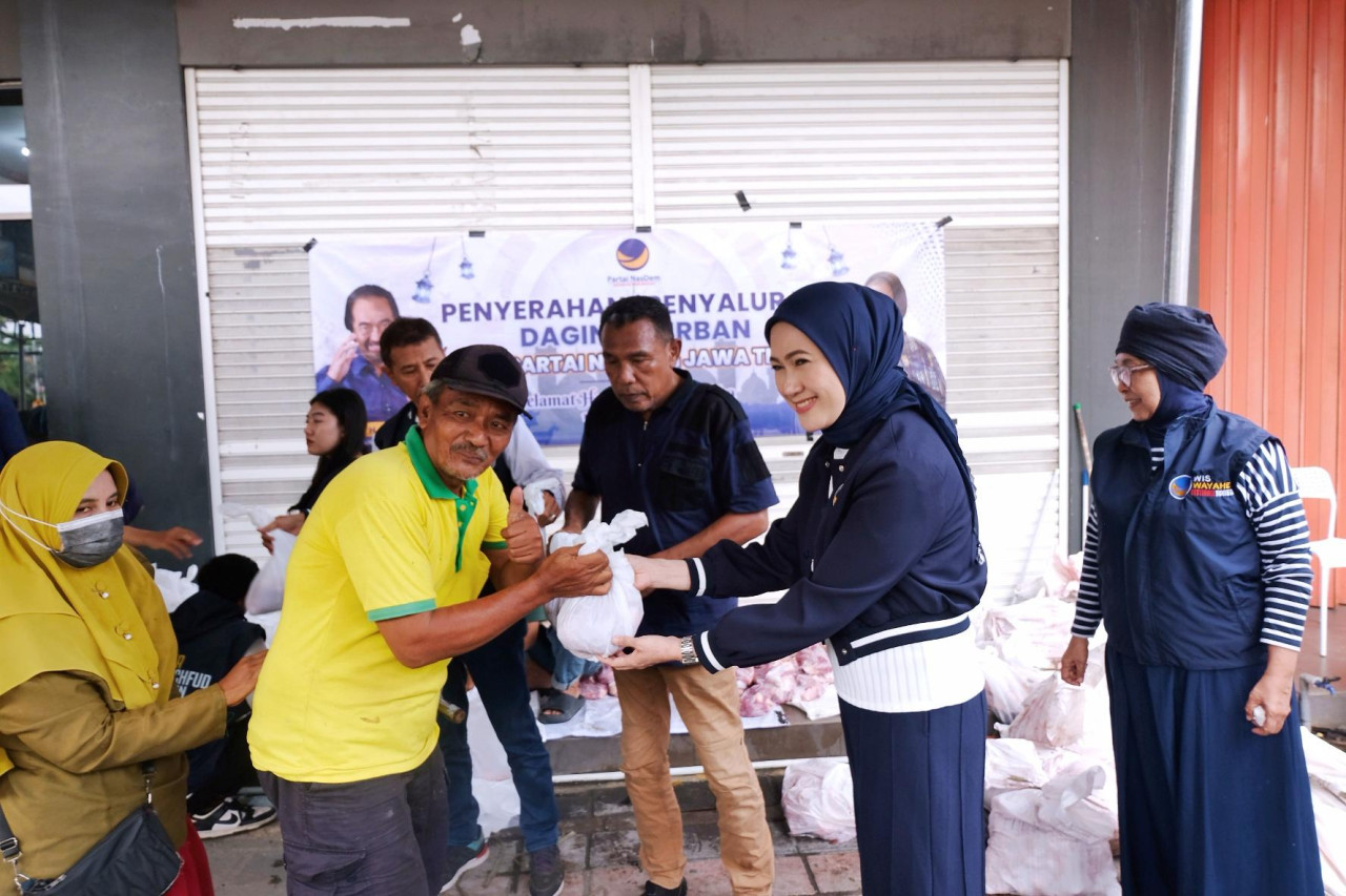 Lita (kanan) saat menyerahkan daging kurban secara simbolis pada warga Surabaya (foto: Nasdem Jatim for jatimnow.com)