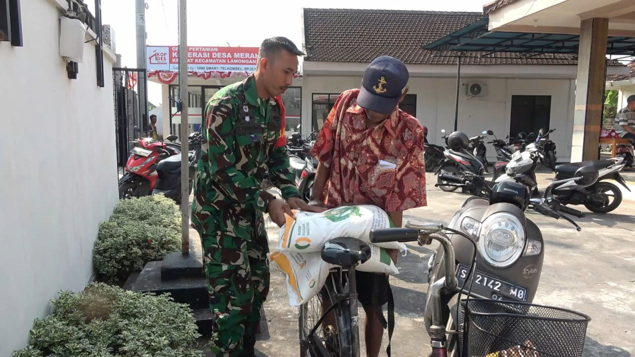 Foto: Serda Teguh Utomo, Babinsa Desa Kramat saat membantu masyarakat mendapat akses pangan murah. ( Adyad Ammy Iffansah/jatimnow.com)