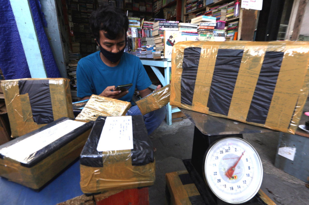 Hasyim, salah satu penjual buku bekas menyiapkan paket buku yang akan dikirim ke pelanggan. Foto: Ali Masduki/jatimnow.com