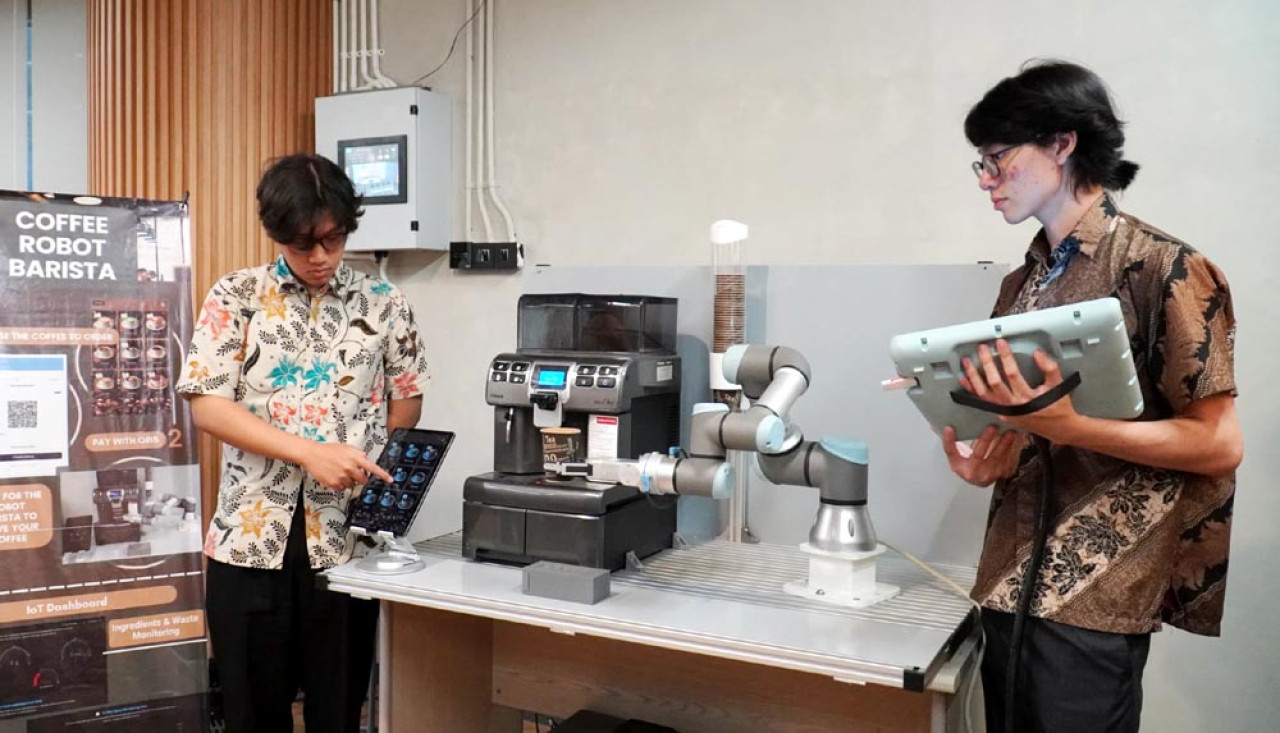 Idham Yuma (kiri) dan Alvin Christopher membuat karya Robot Barista peracik kopi otomatis lengkap dengan sistem pembayaran digital. Foto: Humas PCU