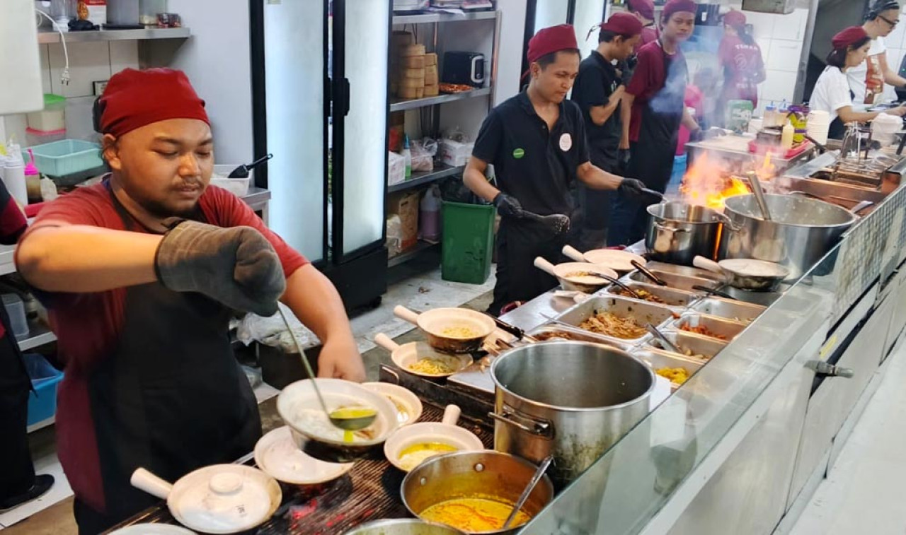Para juru masak tengah sibuk menyiapkan pesanan pelanggan di Kedai Teman Setia di Surabaya.  Foto: Ali Masduki/jatimnow.com