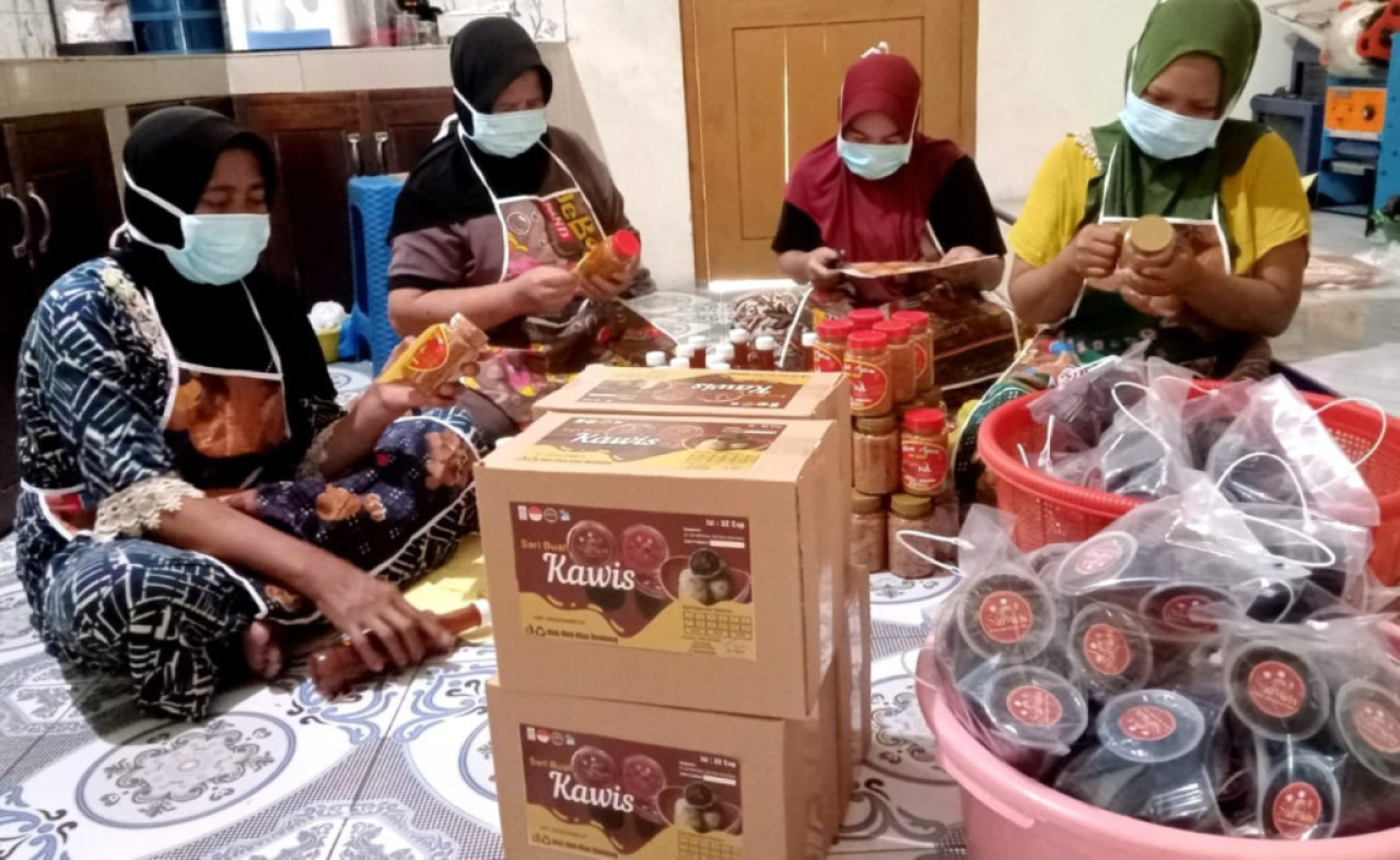 Ibu rumah tangga anggota KWT Annisa memberikan label pada botol produk sirup di rumah produksi KWT Annisa yang berlokasi di Desa Glebeg, Kecamatan Sulang, Rembang, Jawa Tengah. (Foto: SIG for JatimNow.com)