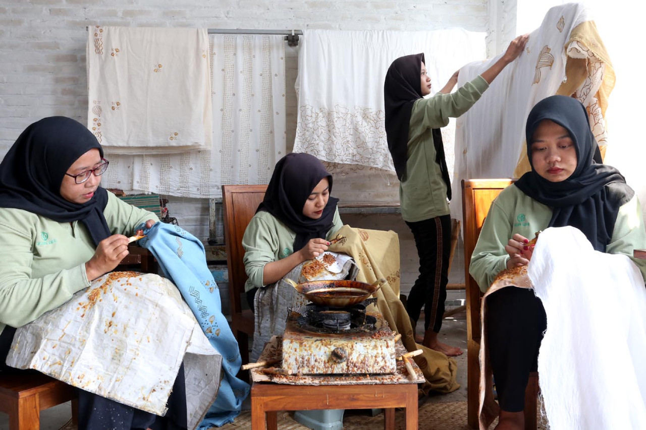 Sejumlah pekerja menyelesaikan proses batik di Workshop Ulur Wiji, di Desa Pandankrajan, Kabupaten Mojokerto, Jawa Timur. (Foto: Ali Masduki/JatimNow.com)