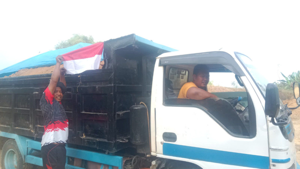 Salah satu warga memasang bendera merah putih di truk. Foto/JatimNow.com