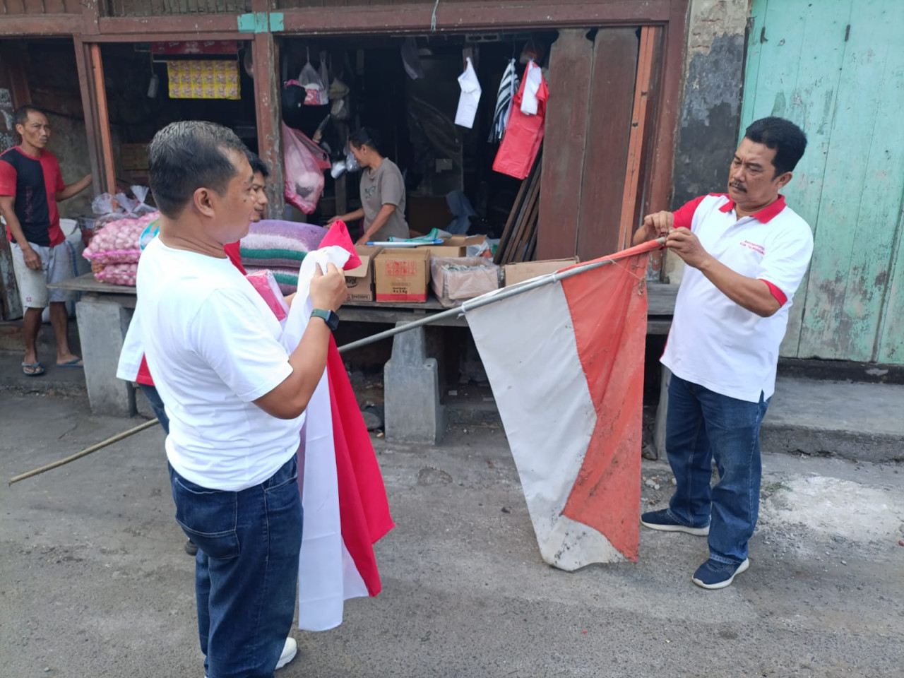 Foto: Anggota PWI Tulungagung ganti bendera merah putih usang dengan yang baru (Bramanta/jatimnow.com)