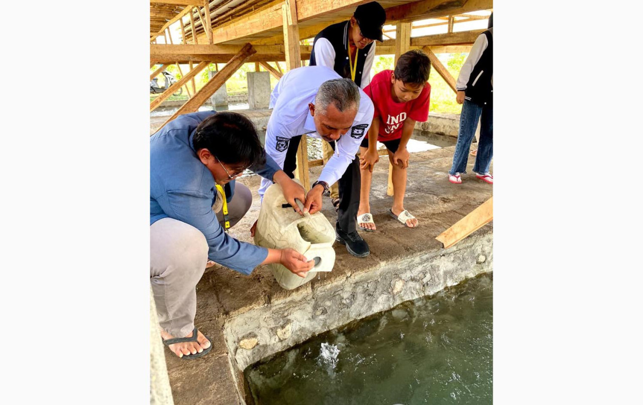 Mahasiswa Unitomo langsung bergerak cepat dengan melakukan praktik penebaran bibit lele ke dalam kolam yang telah disiapkan oleh BUMDes. (Foto/JatimNow.com)