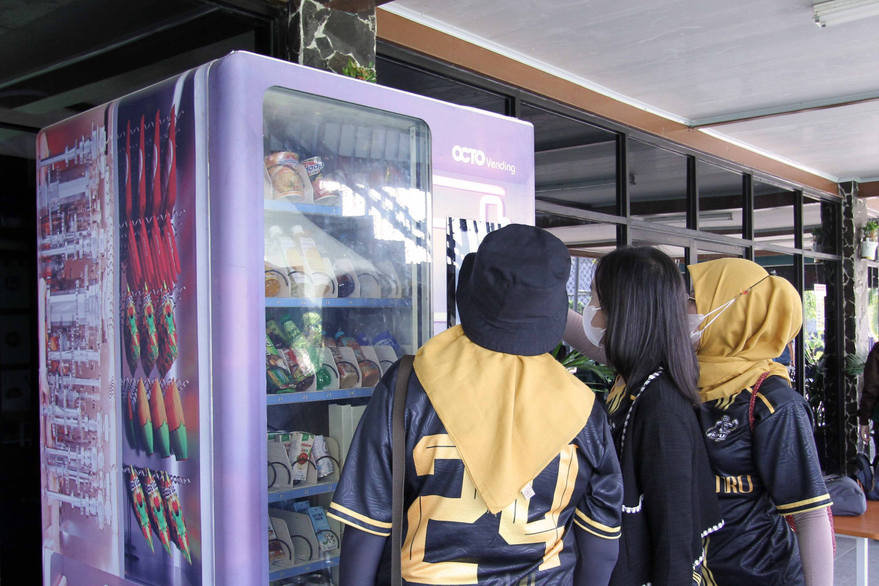 Pengunjung Buyos Sport Center Gresik saat membeli produk di OCTO Vending CIMB Niaga. (Foto: Sahlul Fahmi/jatimnow.com)