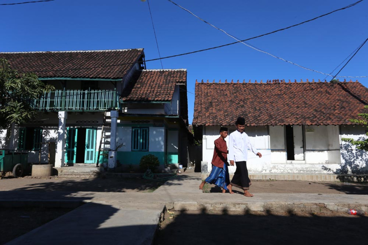 Santri melintas di halaman komplek pondok pesantren Cangaan, Sabtu (02/8/2025). Ponpes di JL. Jaksa Agung Suprapto, Gempeng, Bangil, Pasuruan ini merupakan salah satu pondok pesantren tertua di Nusantara. Foto: Ali Masduki/JatimNow.com