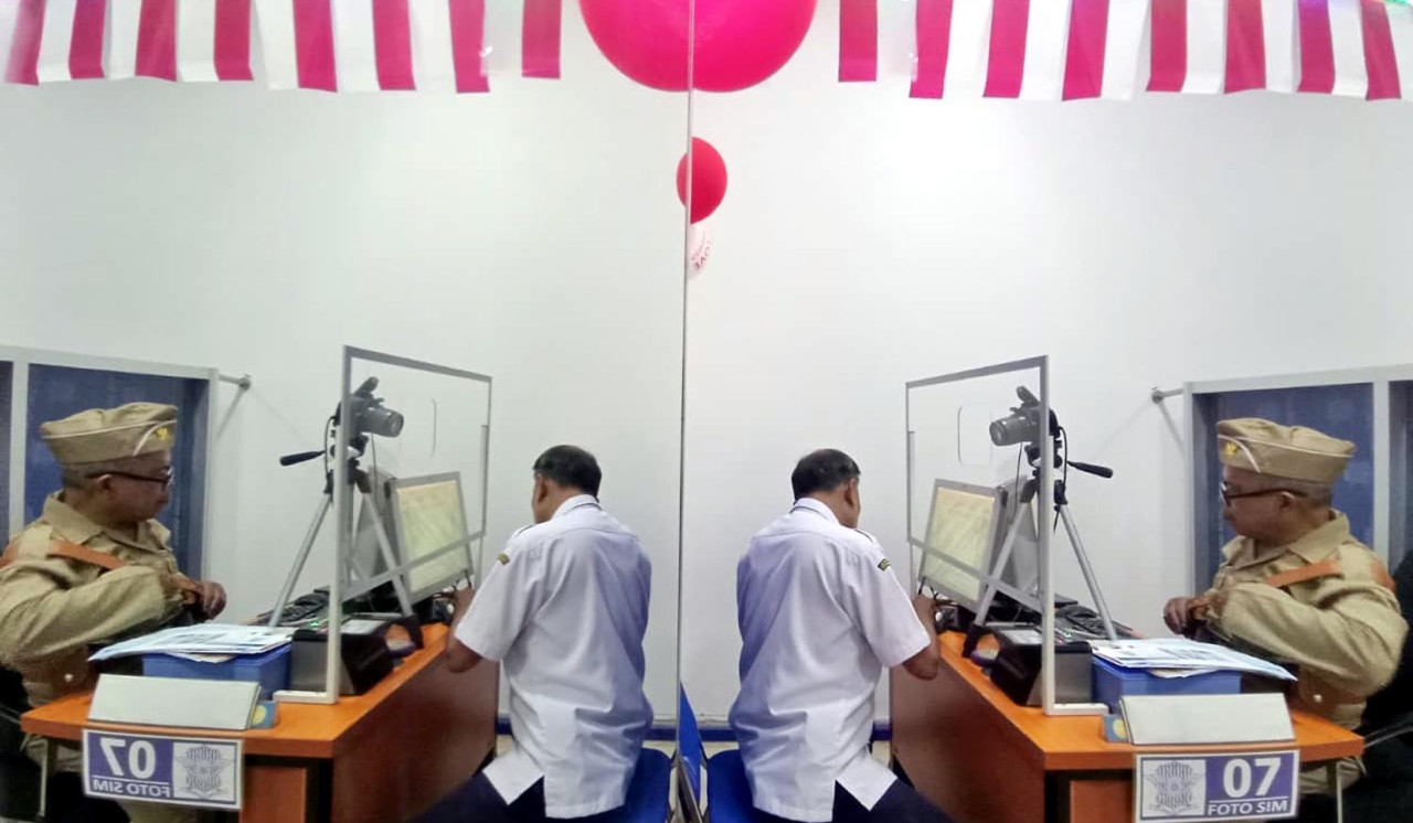 Petugas pelayanan mengenakan kostum pejuang dan veteran saat melayani masyarakat yang mengurus Surat Izin Mengemudi (SIM), Satpas SIM Colombo Surabaya. Foto/JatimNow.com