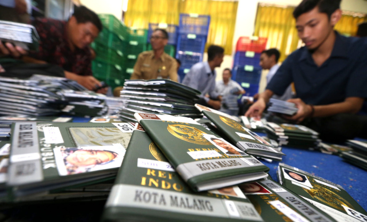 Petugas memeriksa kesesuaian visa dan paspor Jamaah Calon Haji (JCH), di Asrama Haji, Surabaya. Foto: Ali Masduki/JatimNow.com