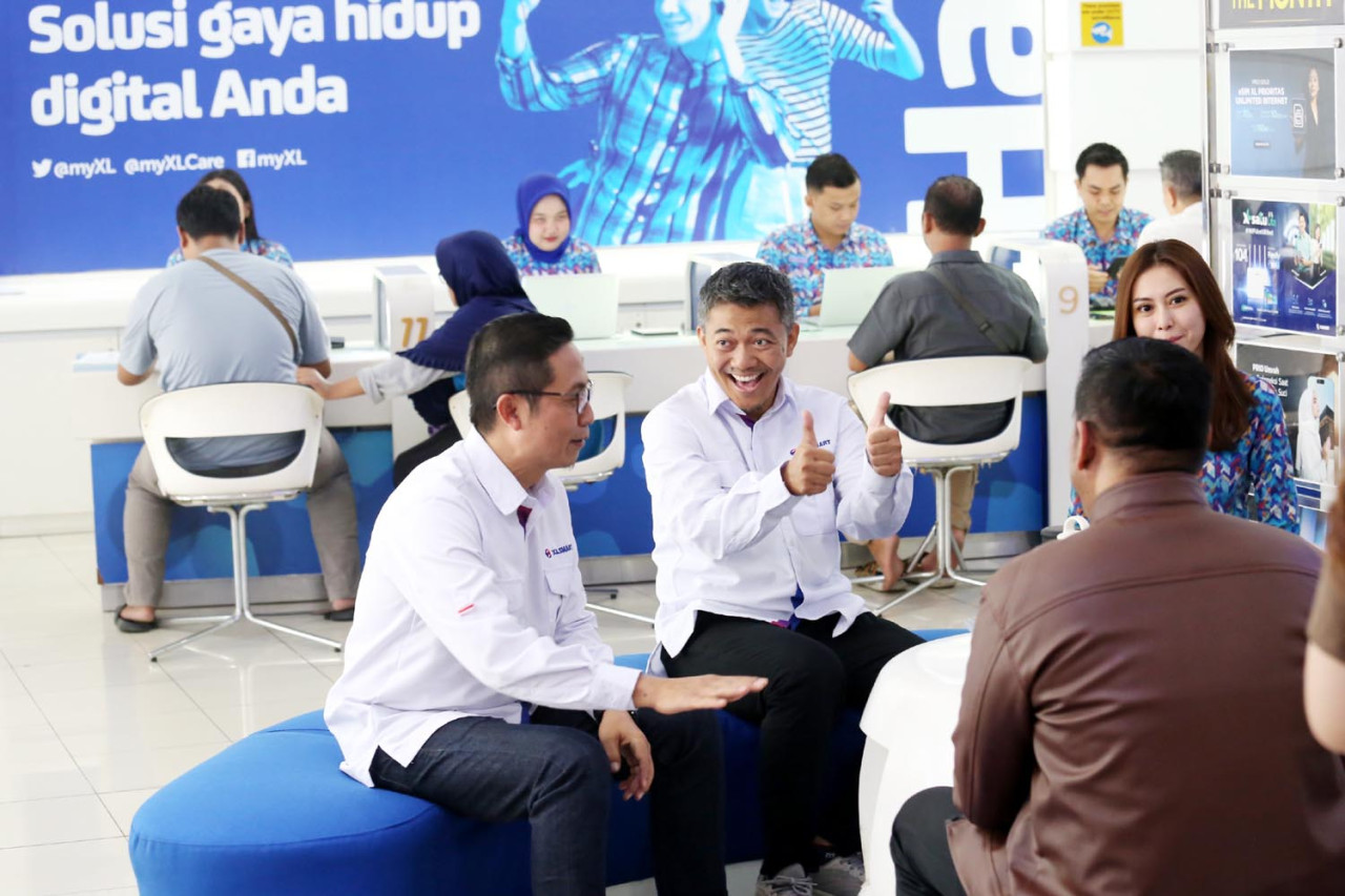 Group Head East Region XLSMART Dodik Ariyanto, bersama Head Direct Channel Region East XLSMART Noval P Wedhasmara, berbincang dengan pelanggan di XL Center Pemuda Surabaya, Kamis (04/9/2025). (Foto: Ali Masduki/JatimNow.com)