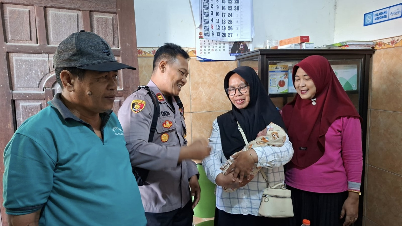 Petugas saat mengamankan bayi. (Foto: Polsek Gurah/jatimnow.com)