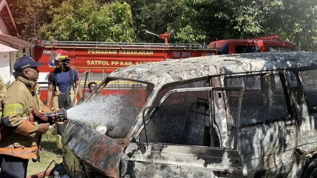 Petugas memadamkan api yang membakar mobil di Kediri. (Foto: PMK Kediri/jatimnow.com)