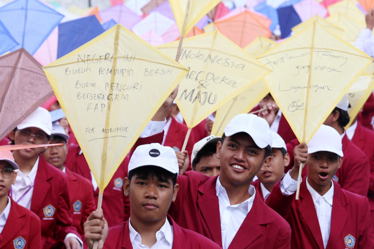 Mahasiswa baru UM Surabaya menulis kritik tajam untuk pemerintah di layangan ketika mengikuti pembukaan Mastama, Ordik, Expo UKM (MOX) 2025) pada Rabu (17/9/25). (Foto: Ali Masduki/JatimNow.com)