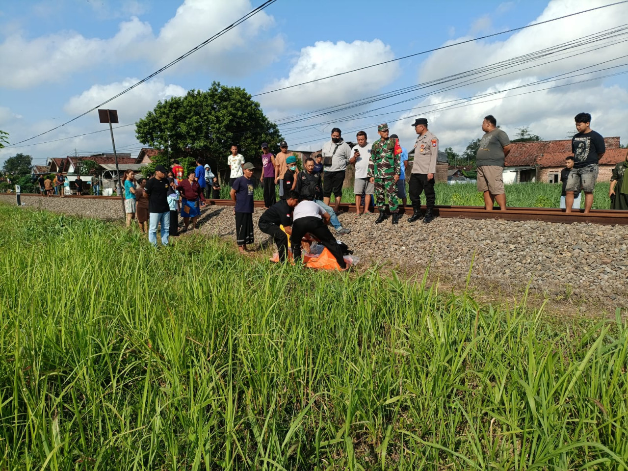 Foto: Petugas mengevakuasi jenazah korban kecelakaan kereta api. (Bramanta/jatimnow.com)