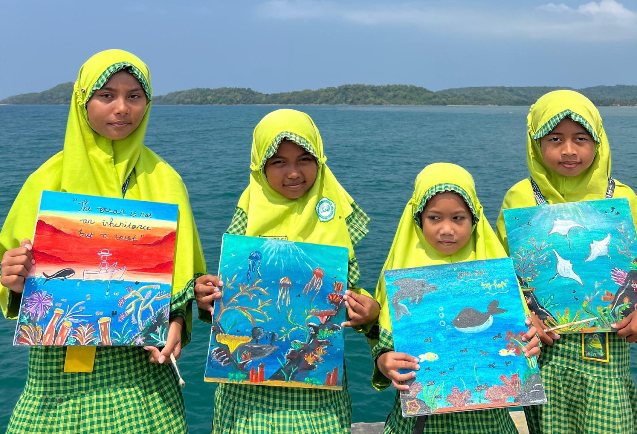 Empat siswa Sekolah Dasar dari Pulau Bawean, Gresik, menunjukkan hasil lukisannya untuk memenangkan kontes internasional. (Foto/Ecoton)