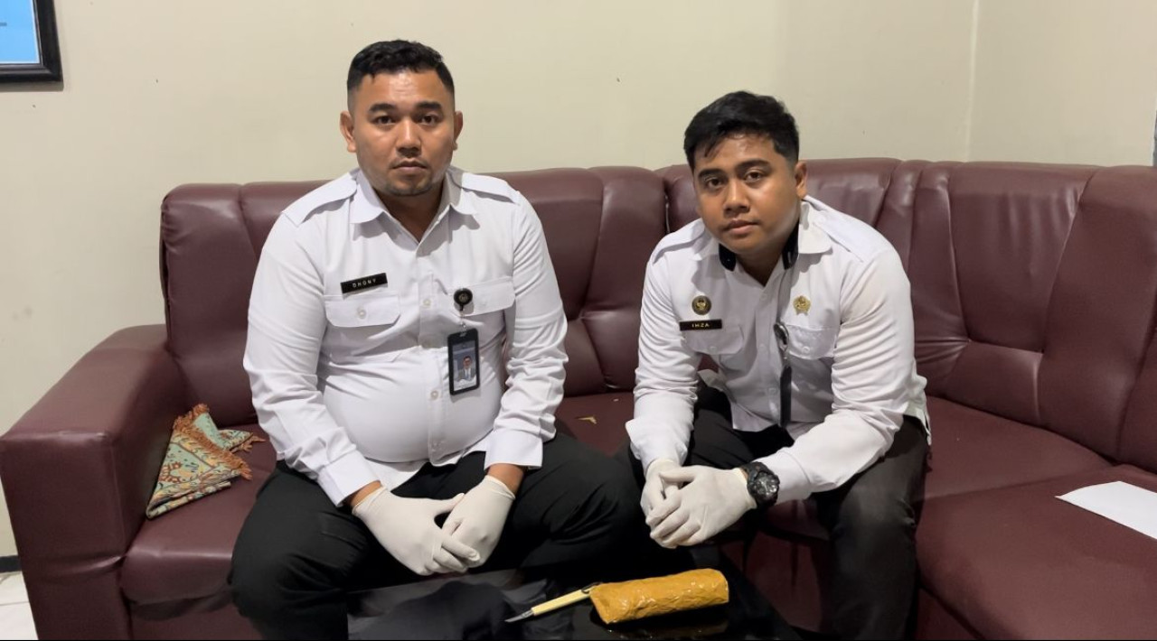 Foto: Petugas bersama bungkusan lakban waran coklat yang berisi handphone. (Lapas Tulungagung/jatimnow.com)