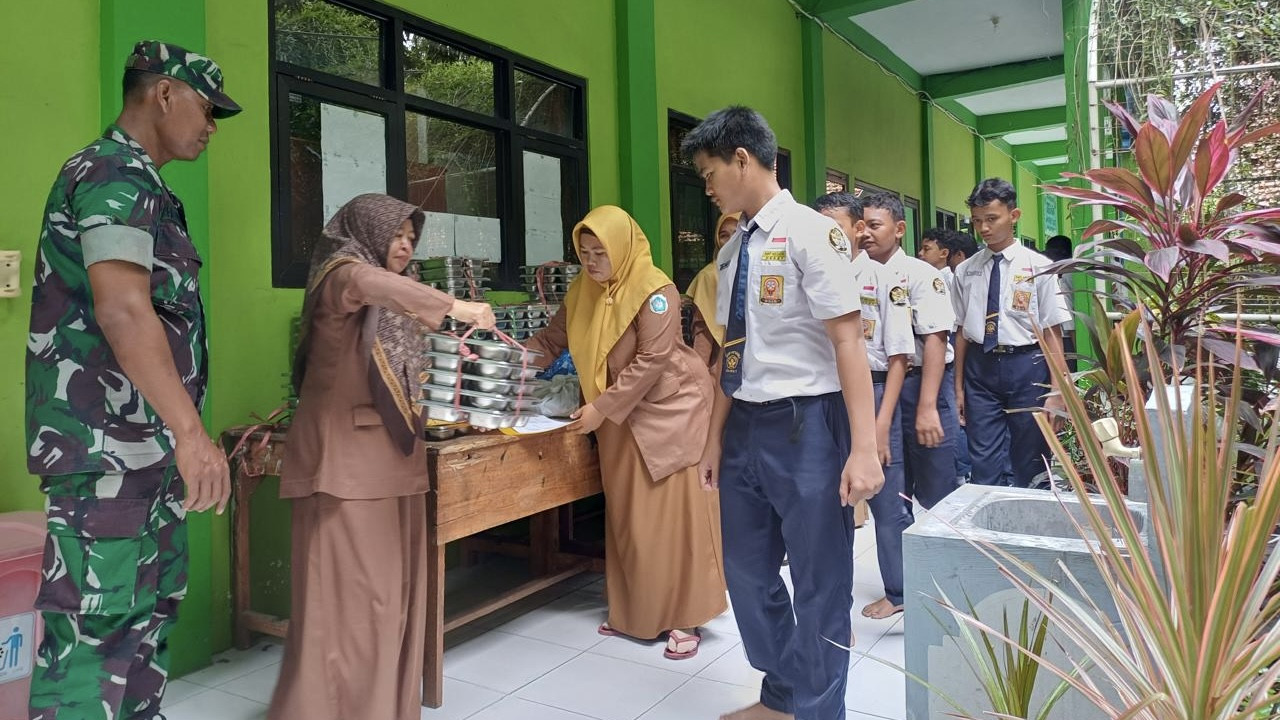 Antrean siswa SMP 1 Deket saat mendapat MBG perdana di sekolah mereka. (Foto: Adyad Ammy Iffansah/jatimnow.com)