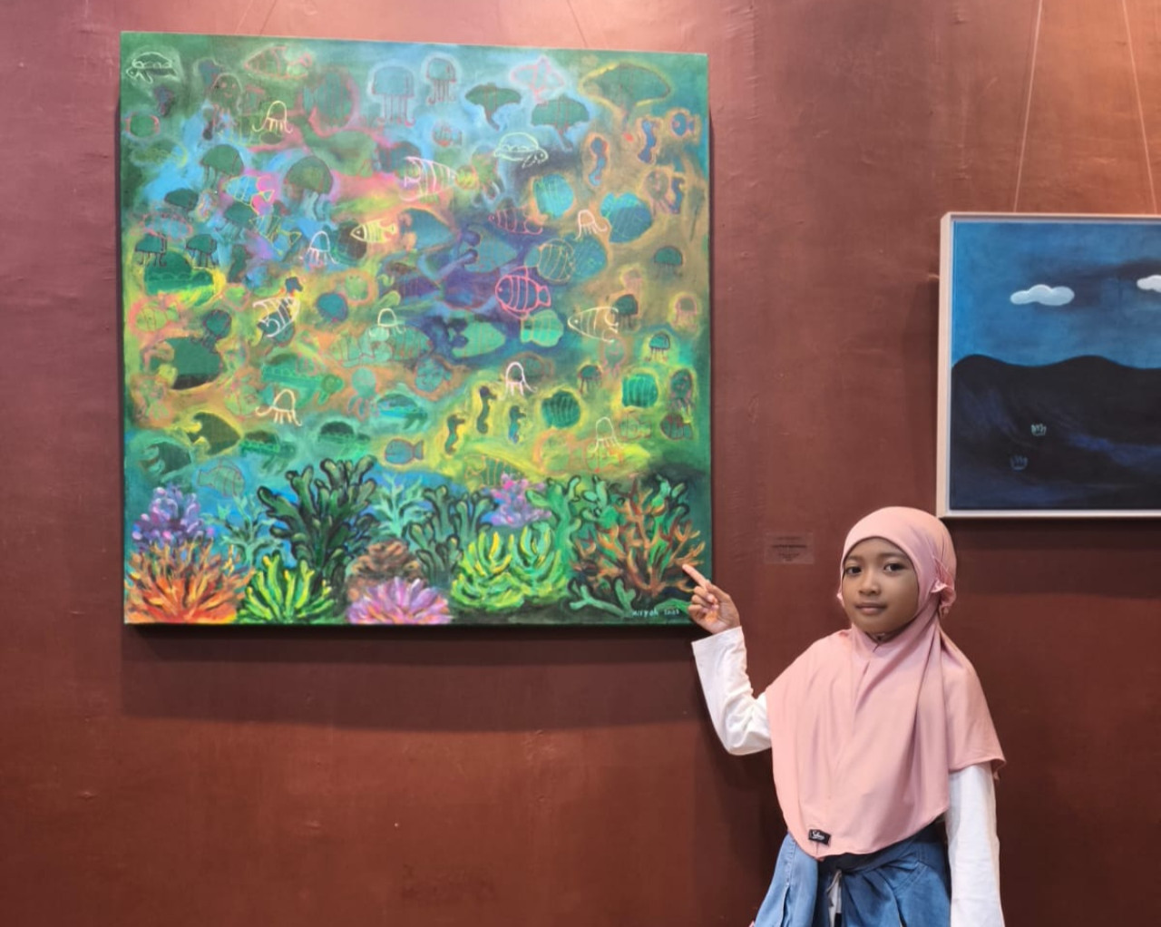 Aisyah Hilya dan karyanya di pameran lukisan tunggal perdana bertema The Colour of Journey". (Foto: Sahlul Fahmi/jatimnow.com)