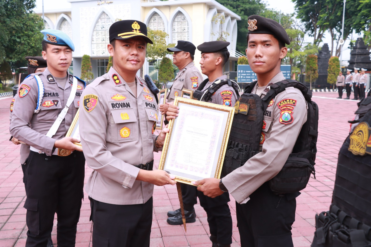 Foto: Kapolres Gresik, AKBP Rovan Richard Mahenu saat memberikan penghargaan kepada personel dan warga berprestasi. (Humas Polres Gresik/jatimnow.com)