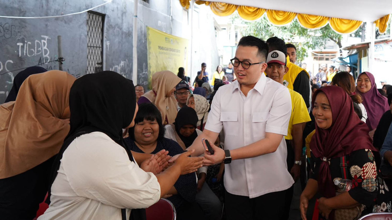 Abraham Sridjaja menyalami warga ketika membagikan 10.000 paket sembako gratis dalam rangka HUT Partai Golkar ke-61. (Foto/Tim Media)