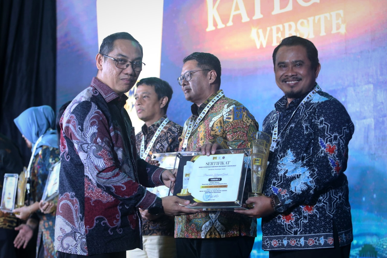 Kabid Statistik dan Informasi Publik Diskominfo Kabupaten Gresik, Zurron Arifin (kanan), saat menerima penghargaan peringkat terbaik III Anugerah Media Humas (AMH) 2025. (Foto: Diskominfo Gresik/jatimnow.com)