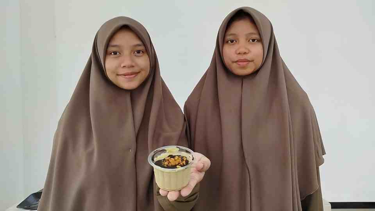 Foto: Dua santri Ponpes Abdul Malik Fajar Malang tunjuukan es krim daun kelor. (M Aris/jatimnow.com)