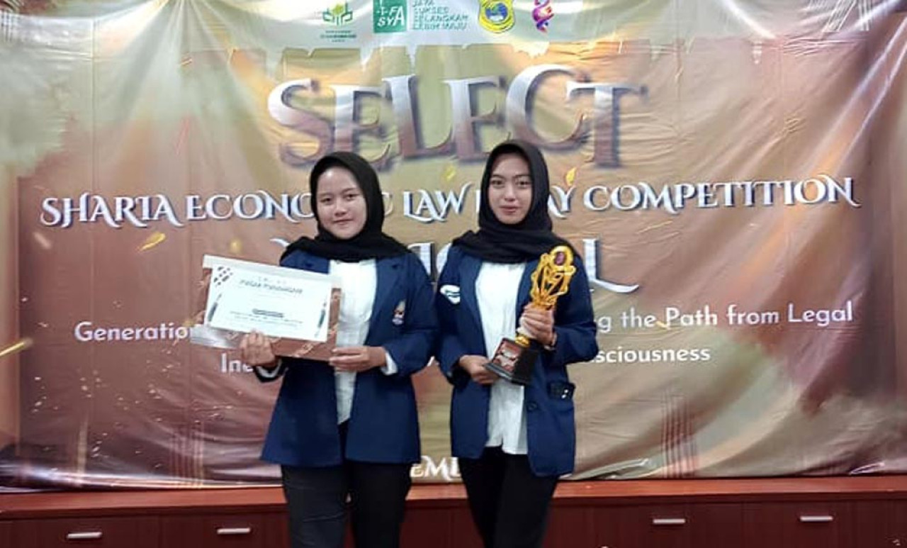 Dua siswi SMAN 3 Ponorogo, Wike Dayinta Widegda (kanan) dan Elfreda Putri Widya Pratiwi (kiri) saat menerima Piagam Penghargaan dan Piala di UIN Ponorogo. (Foto/jatimnow.com)