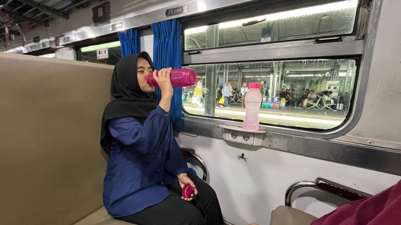 Penumpang kereta api minum dari  tumbler yang dibawa. (Foto/Humas KAI)