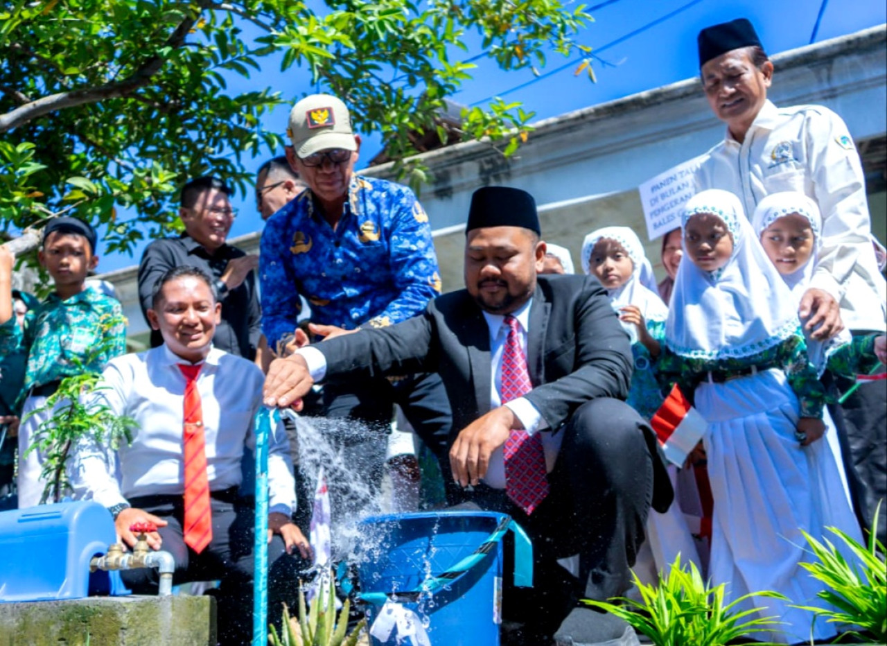Bupati Gresik Fandi Akhmad Yani saat mencoba kran air bersih di salah satu rumah warga di Kecamatan Duduksampeyan, Gresik. (Foto: Diskominfo Gresik)