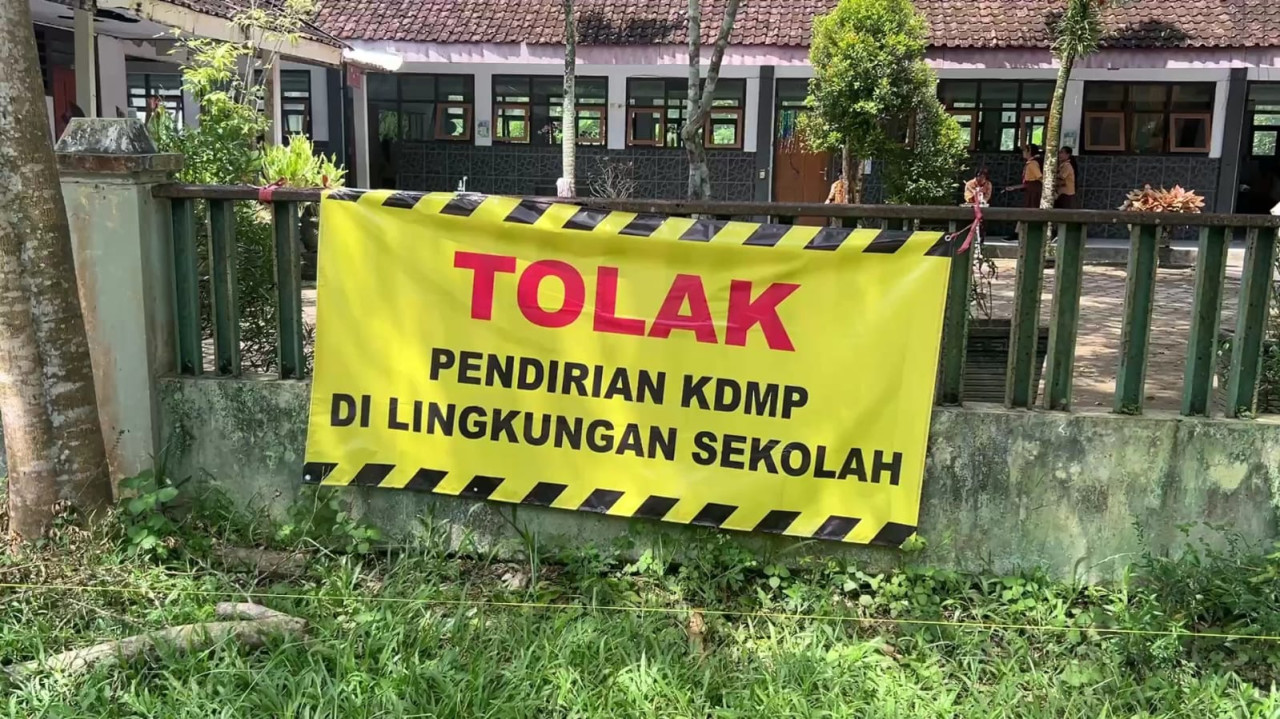 Foto: Spanduk penolakan pembangunan KDMP di Trenggalek. (Bramanta/jatimnow.com)