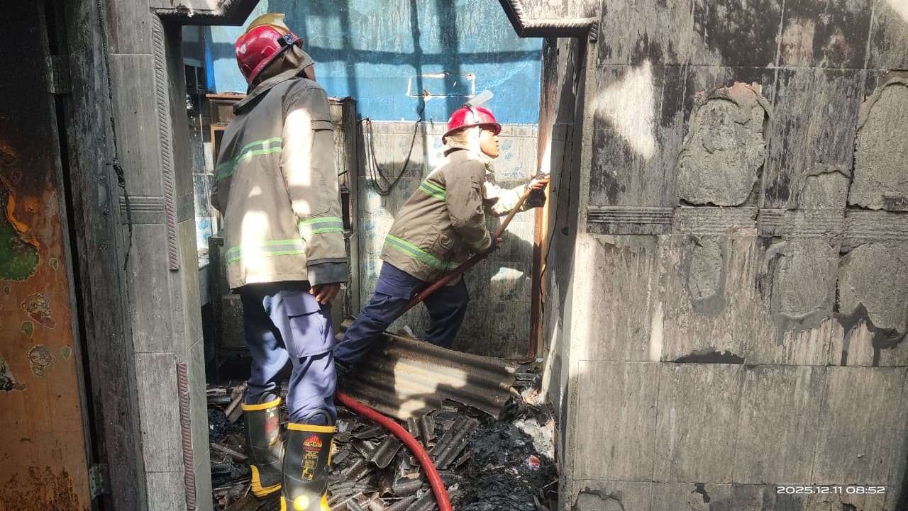 Foto: Petugas Damkar Lamongan saat melakukan pembasahan di rumah warga Kalitengah. (Adyad Ammy Iffansah/jatimnow.com)