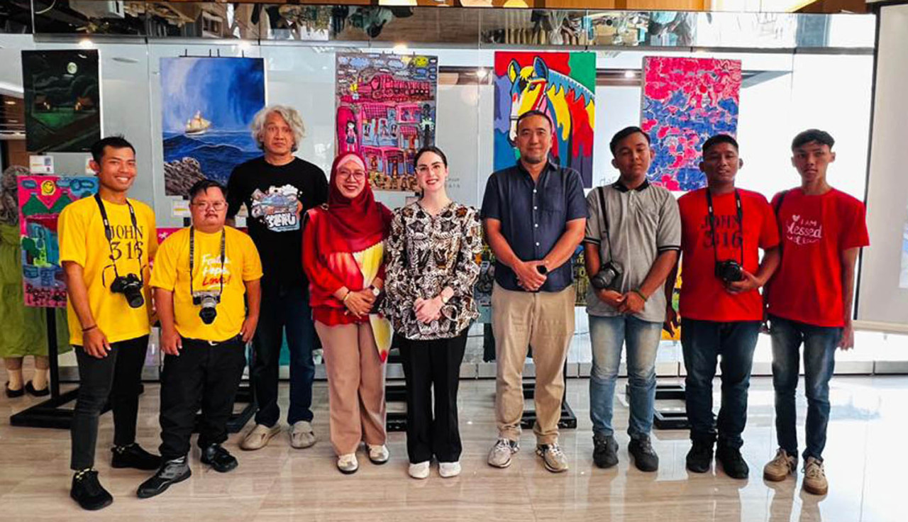 Para seniman muda disabilitas berfoto bersama mentor dan penyelenggara di sela-sela pameran "Melihat Bersama #SetaraBerkarya" di Pacific Sky Hall, Surabaya, Sabtu (14/12/2025). (Foto: Dafam Pacific Caesar/jatimnow.com)