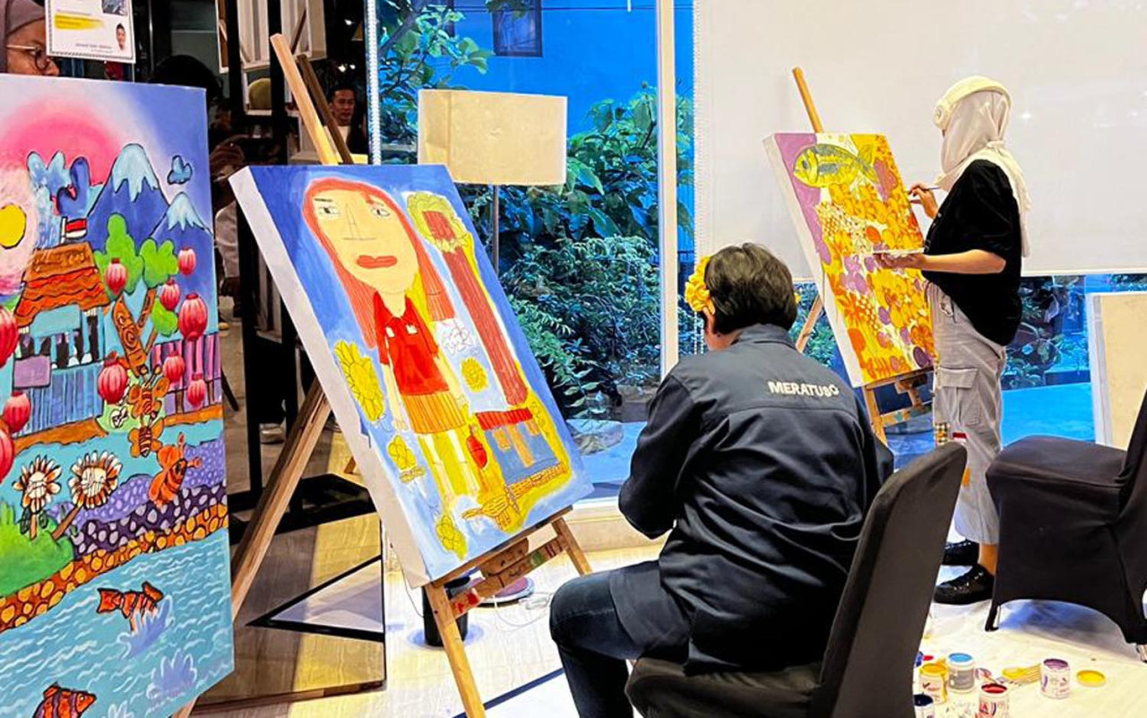 Tata dan Neneng, dua anak difabel dari UPTD Kampung Anak Negeri, mempertunjukkan kemampuan luar biasa dalam seni lukis. (Foto: Dafam Pacific Caesar/jatimnow.com).