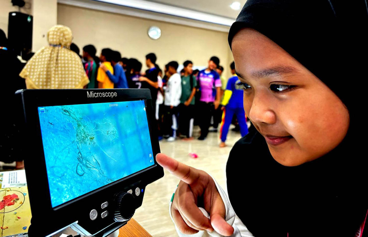 Siswa melakukan pengamatan langsung menggunakan mikroskop portabel. (Foto: Ecoton/jatimnow.com)