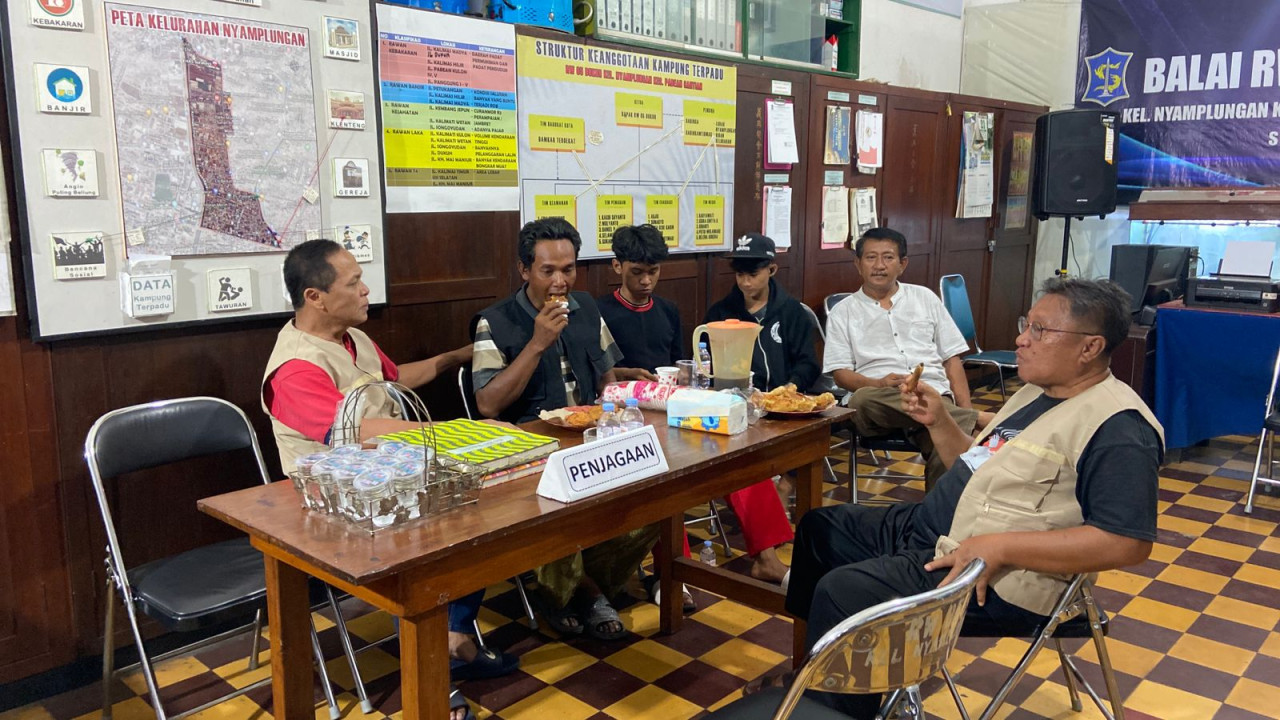 Suasana hangat di Balai RW 5 Kelurahan Nyamplungan, Kecamatan Pabean Cantian, Surabaya. Bapak-bapak dan anak muda giliran berjaga demi keamanan wilayah mereka. (Foto: Yanuar Dedy/jatimnow.com)