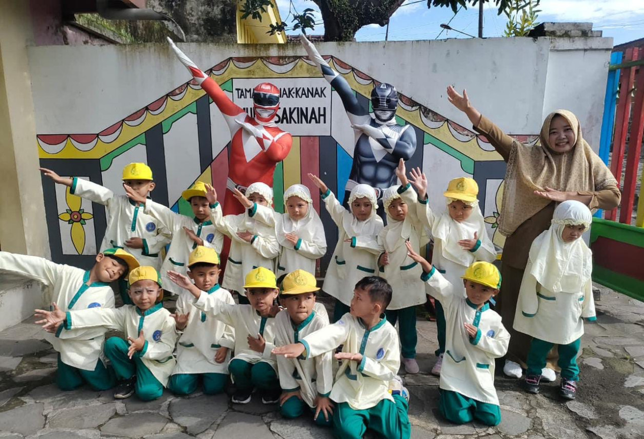 Anak-anak dan guru foto bersama petugas MBG berkostum Power Rangers. (Foto: Agung for jatimnow.com)