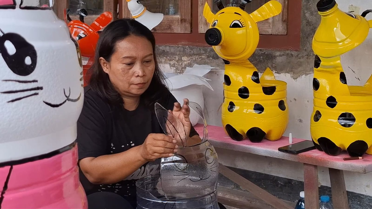 Foto: Mimi Hani saat membuat pot karakter dari galon bekas air mineral. (Bramanta/jatimnow.com)