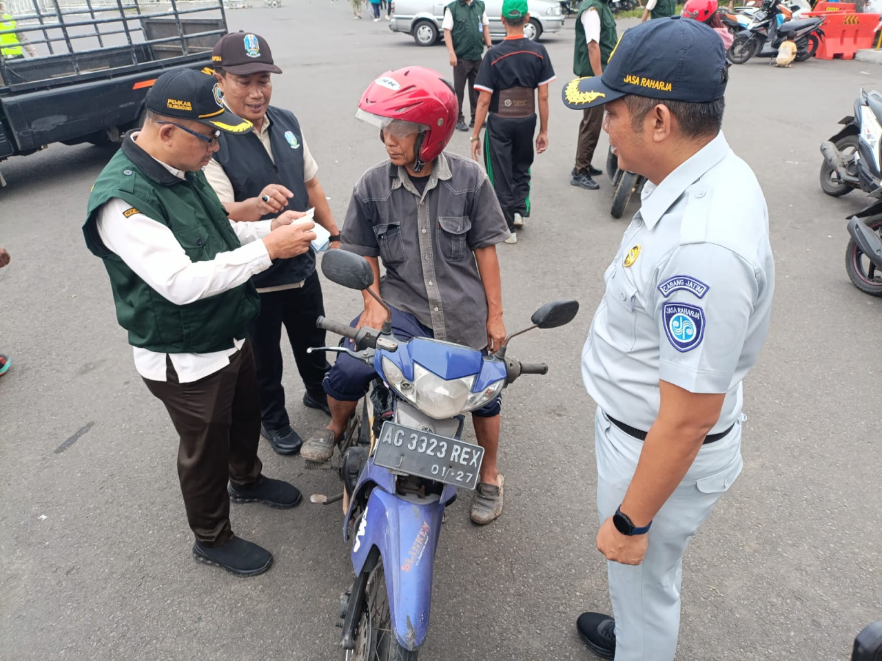 Foto: Petugas memeriksa bukti pembayaran pajak pengendara motor di Tulungagung. (Bramanta/jatimnow.com)