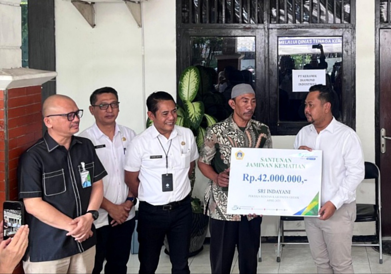 Bupati Gresik H. Fandi Akhmad Yani, secara simbolis menyerahkan Santunan Jaminan Kematian (JKM). (Foto: BPJS Gresik/jatimnow.com)