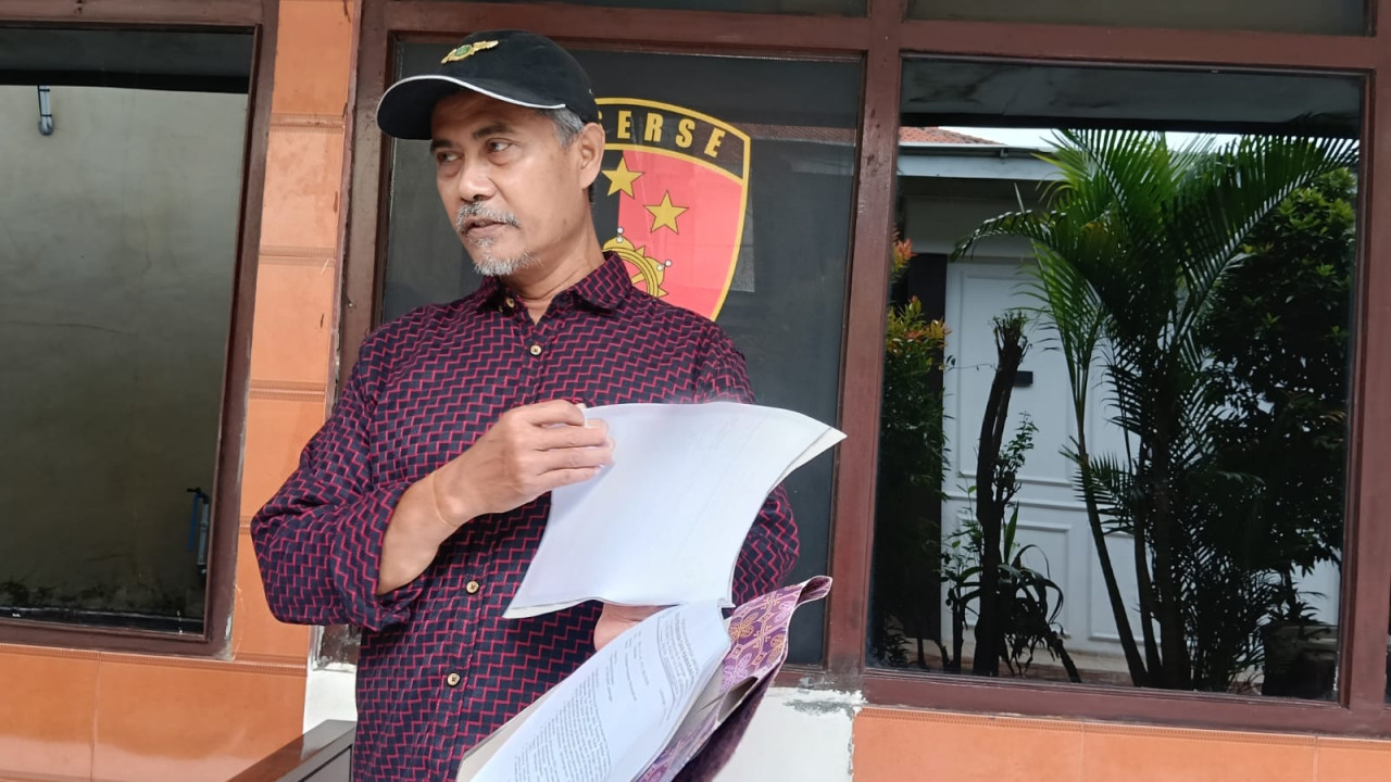 Pelapor dugaan alih fungsi LSD untuk perumahan saat menyerahkan berkas petunjuk kepada penyidik Unit III Tipikor Satreskrim Polres Lamongan. (Foto: Adyad Ammy Iffansah/jatimnow.com)
