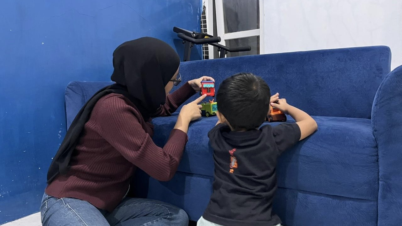 Husnika sedang bermain bersama anaknya Birru di salah satu sudut rumahnya. (Foto: Yanuar Dedy/jatimnow.com)